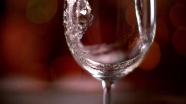 Beyaz şarabı cama dökmenin süper yavaş bir yolu. Yüksek hızlı sinema kamerası, 1000 fps..