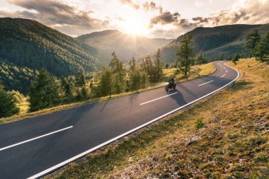 Alp yolunda motosiklet sürücüsü, Avusturya, Avrupa. Açık hava fotoğrafçılığı, dağ manzarası. Seyahat ve spor fotoğrafçılığı. Hız ve özgürlük kavramı