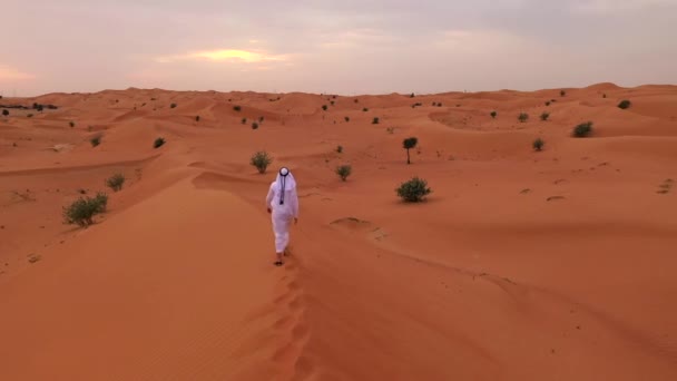 Luftaufnahmen Eines Traditionell Gekleideten Arabischen Mannes Der Wüstensanddünen Wandelt — Stockvideo
