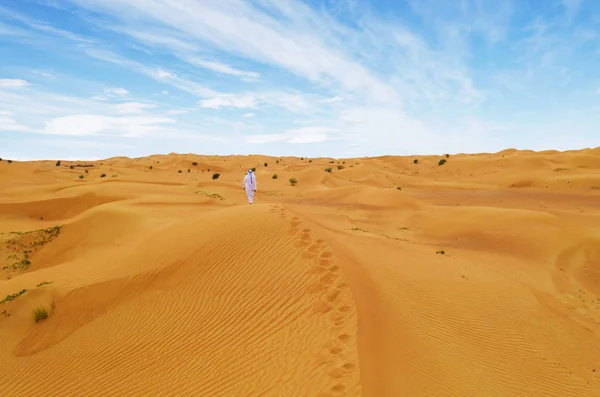 アラビア人が砂漠を歩いています 伝統的なアラビアのスーツに身を包んだ — ストック写真