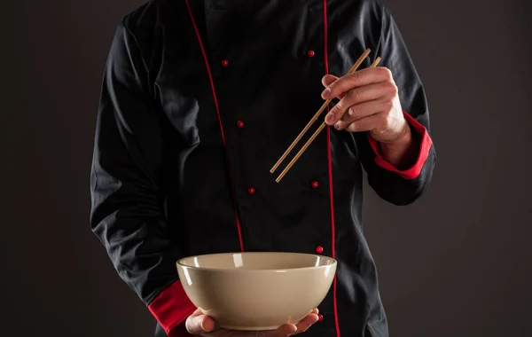 Maestro chef sosteniendo palillos de madera y tazón — Foto de Stock