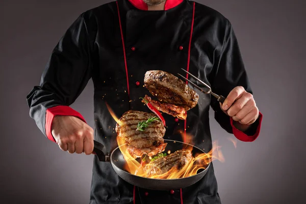 Primer plano del chef lanzando filetes de carne al aire — Foto de Stock