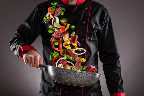 Closeup of chef throwing beef meat with vegetable — Stock Photo, Image