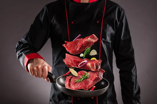 Closeup of chef throwing raw steaks into the air — Stock Photo, Image