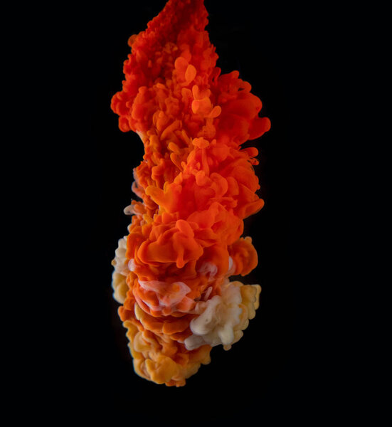 Coloured acrylic ink mixing in water on black