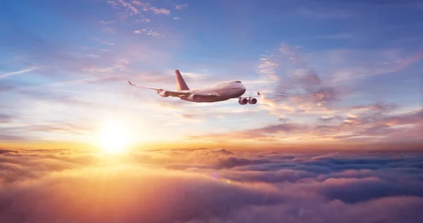 Avión comercial sobrevolando dramático atardecer — Foto de Stock