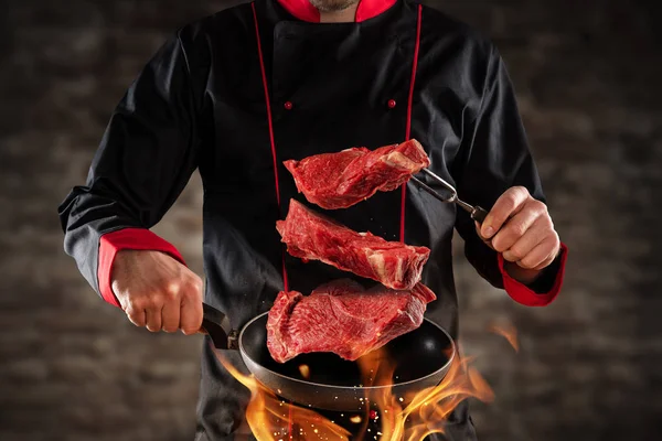 Primer plano del chef lanzando filetes de carne cruda — Foto de Stock