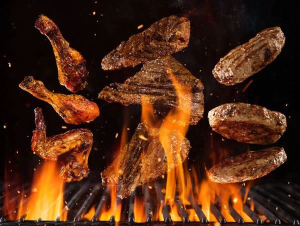 Bifes de carne de vaca voadora, hambúrgueres e pedaços de frango — Fotografia de Stock