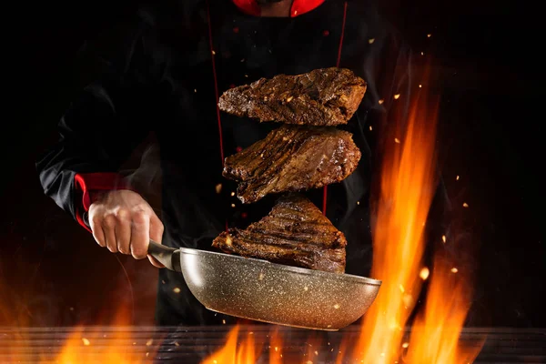 Primo piano dello chef che prepara bistecche di manzo sopra la griglia . — Foto Stock