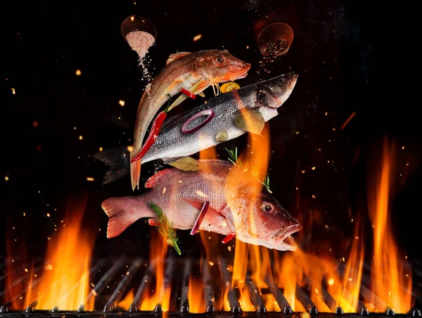 Flying sea fish above burning grill grid — Stock Photo, Image