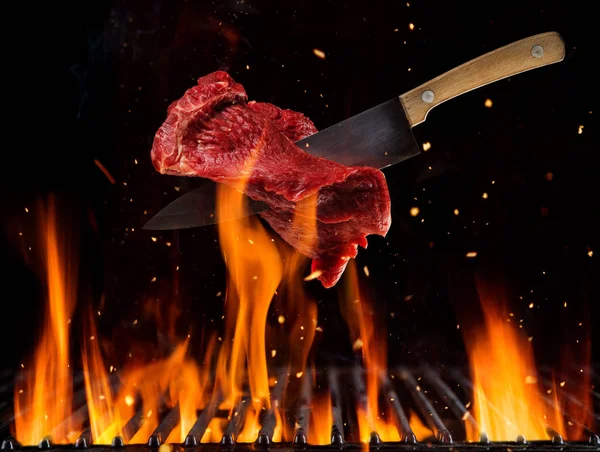 Repülő nyers marha steak fent égő grill rács — Stock Fotó