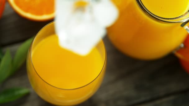 Mouvement Super Lent Tomber Glaçon Dans Verre Avec Jus Orange — Video