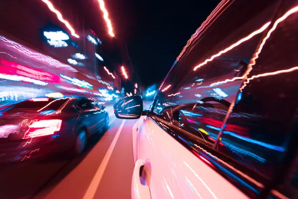 POV автомобиля, движущегося по ночному городу с размытым движением — стоковое фото