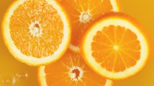 Superlangzame Beweging Van Sinaasappelschijfjes Die Sap Vallen Gefilmd Hoge Snelheid — Stockvideo