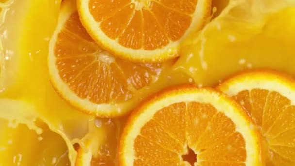 オレンジのスライスの超遅い動きはジュースに落ちる 高速フィルムカメラで撮影しました — ストック動画