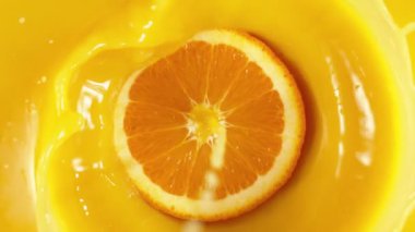 Portakal dilimlerinin çok yavaş bir şekilde meyve suyuna dökülmesi. Yüksek hızlı sinema kamerası, 1000 fps..