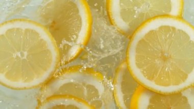 Limon dilimlerinin suya düşmesi çok yavaş bir hareket. Yüksek hızlı sinema kamerası, 1000 fps..