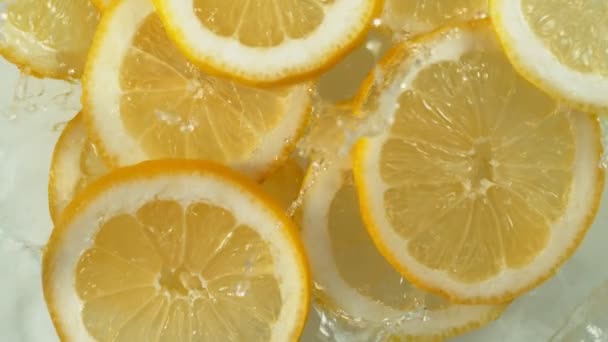 Super Zeitlupe Fallender Zitronenscheiben Ins Plätschernde Wasser Gefilmt Mit High — Stockvideo