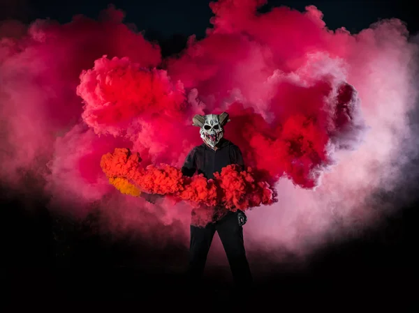 Diable avec masque effrayant entouré de fumée rouge — Photo