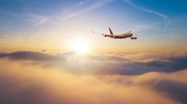 Avião comercial voando sobre o pôr do sol dramático — Fotografia de Stock