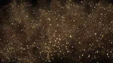 Siyah zemin üzerinde ışıldayan altın parçacıkların süper yavaş çekimi. Sığ odak derinliği. Yüksek hızlı sinema kamerası, 1000 fps..