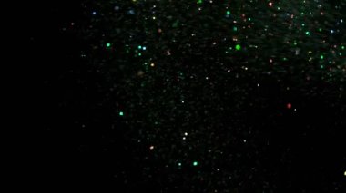 Siyah arka plan üzerine süper ışıltılı, yavaş gümüş parçacıkları. Odak sığ derinliği. Yüksek hız sinema kamerası, 1000 fps üzerinde filme.