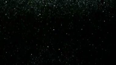 Siyah arka plan üzerine süper ışıltılı, yavaş gümüş parçacıkları. Odak sığ derinliği. Yüksek hız sinema kamerası, 1000 fps üzerinde filme.