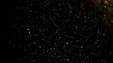 Siyah arka plan üzerinde parlak renkli parçacıkların süper yavaş hareket, düşük dof. Yüksek hızlı sinema kamera, 1000 fps filme.