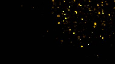 Siyah zemin üzerinde ışıldayan altın parçacıkların süper yavaş çekimi. Sığ odak derinliği. Yüksek hızlı sinema kamerası, 1000 fps..