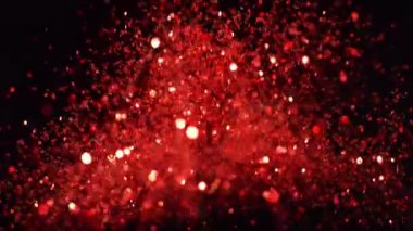 Siyah arka plan üzerine süper ışıltılı, yavaş kırmızı parçacıklar. Odak sığ derinliği. Yüksek hız sinema Kamerası, 1000 fps üzerinde filme.