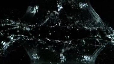 Siyah arka planda izole edilmiş çok yavaş su sıçratma hareketi. Çok hızlı bir kamerayla çekildi, 1000 fps..