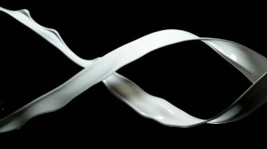 Siyah arka plan üzerinde dönen iki süt sıçramaları Süper yavaş hareket. Çok yüksek hızlı kamera, 1000 fps filme.