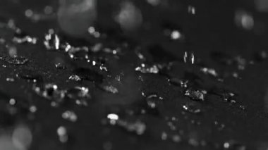 Ayrıntılı olarak su geçirmez bez doku üzerine düşen su damlaları Süper yavaş hareket. Yüksek hızlı sinema kamera, 1000 fps filme.