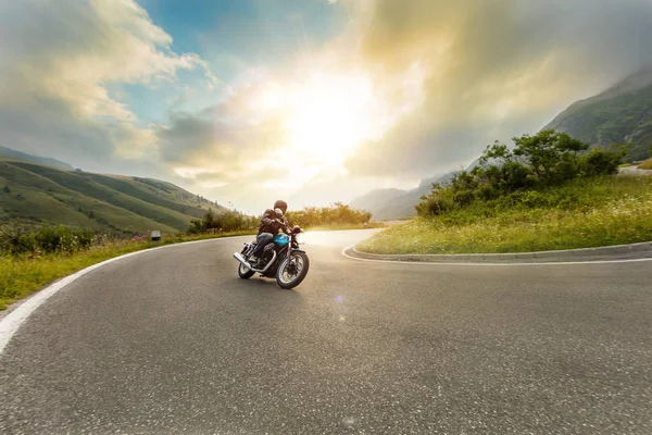 Motorcykelförare kör i alpint landskap — Stockfoto