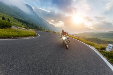Alp manzarasında motosiklet sürücüsü.