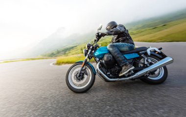 Alp manzarasında motosiklet sürücüsü.