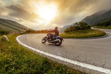 Alp manzarasında motosiklet sürücüsü.