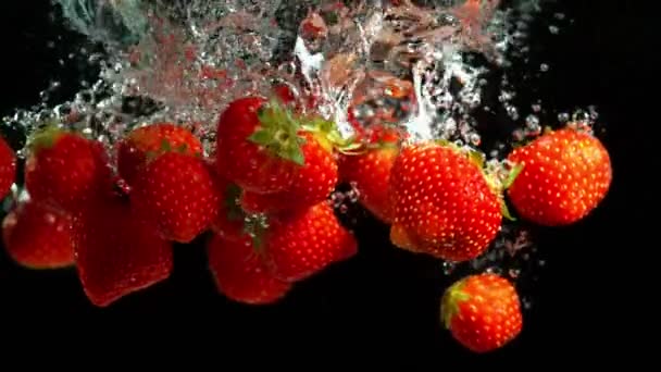 黒い背景に水にイチゴを落とすスーパースローモーション 高速シネマカメラで撮影 1000 Fps — ストック動画