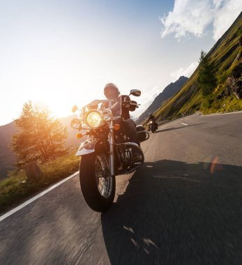 Alp manzarasında motosiklet sürücüsü.