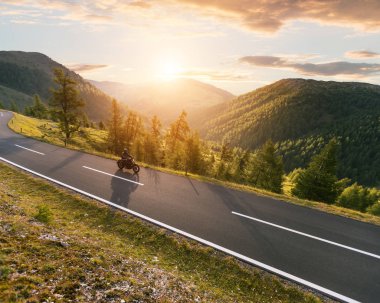 Alp manzarasında motosiklet sürücüsü.