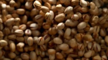 Siyah arka plan üzerinde uçan antep fıstığı Süper yavaş hareket. Yüksek hızlı sinema kamera, 1000 fps filme.