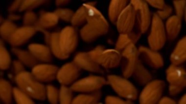 Siyah arka plan üzerinde uçan badem fındık Süper yavaş hareket. Yüksek hızlı sinema kamera, 1000 fps filme.