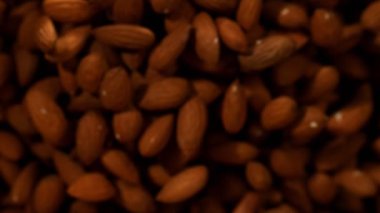 Siyah arka plan üzerinde uçan badem fındık Süper yavaş hareket. Yüksek hızlı sinema kamera, 1000 fps filme.