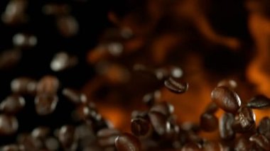 Alevler ile uçan kahve çekirdekleri Süper yavaş hareket. Yüksek hızlı sinema kamera, 1000 fps filme.