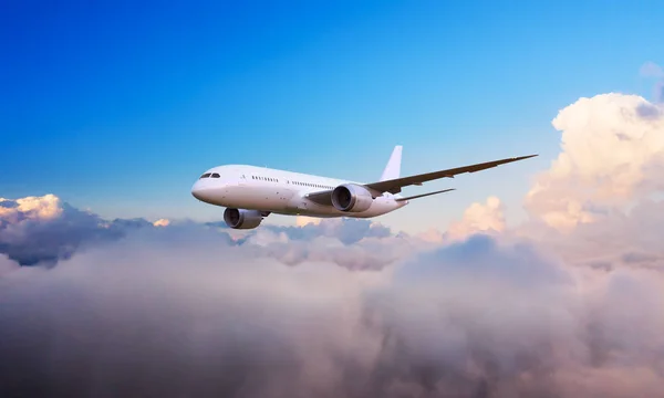 Passengers commercial airplane flying above clouds Royalty Free Stock Images