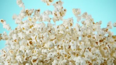 Renkli arka plan üzerine düşen patlamış mısır Süper yavaş hareket. Yüksek hızlı sinema kamera, 1000fps filme.