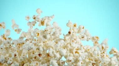 Renkli arka plan üzerine düşen patlamış mısır Süper yavaş hareket. Yüksek hızlı sinema kamera, 1000fps filme.
