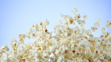 Renkli arka plan üzerine düşen patlamış mısır Süper yavaş hareket. Yüksek hızlı sinema kamera, 1000fps filme.