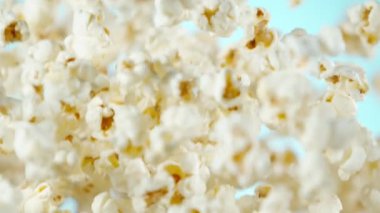 Renkli arka plan üzerine düşen patlamış mısır Süper yavaş hareket. Yüksek hızlı sinema kamera, 1000fps filme.