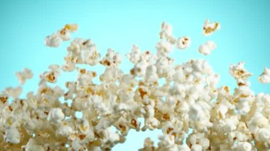 Renkli arka plan üzerine düşen patlamış mısır Süper yavaş hareket. Yüksek hızlı sinema kamera, 1000fps filme.